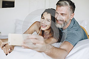 Honeymooners taking a selfie in bed