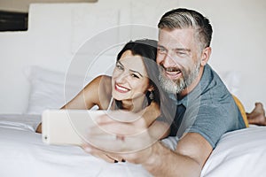 Honeymooners taking a selfie in bed