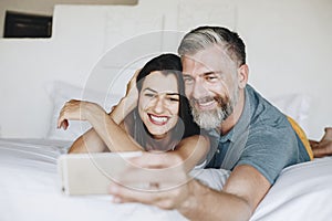 Honeymooners taking a selfie in bed photo