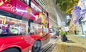 HONG KONG - APRIL 2014: Red buses along city streets at night. T