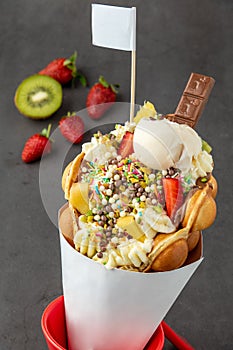 Hong kong or bubble waffle with ice cream, fruits, chocolate sauce and colorful candy