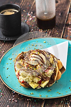 Hong kong or bubble waffle with ice cream, fruits, chocolate sauce and colorful candy