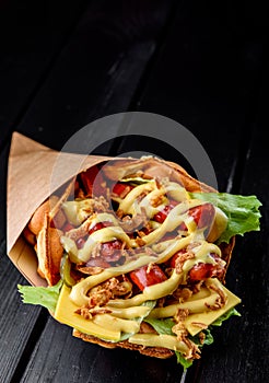 Hong Kong bubble waffles sandwich with sausage, cheese and vegetables on black wooden table