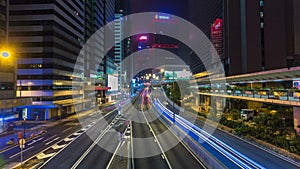 Hong Kong Business District timelapse at Night. Corporate building at the back and busy traffic across the main road at