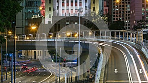 Hong Kong Business District timelapse at Night. Corporate building at the back and busy traffic across the main road at