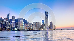 Hong Kong, China skyline panorama with skyscrapers day to night from across Victoria Harbor timelapse.