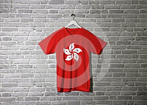 Hong Kong flag on shirt and hanging on the wall with brick pattern wallpaper