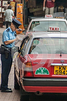 Traffic warden writes a car up for infraction on Hong Kong Island China