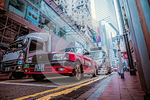HONG KONG - May 19, 2023: A red taxi at a traffic light in Hong Kong. Low angle view
