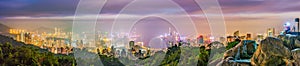 Hong Kong night panorama wide view of Victoria Harbour skyline from Red incense burner summit,Misty night