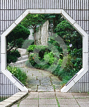 Octogonal shaped entrance to the park in Hong Kong with various greenery on background.