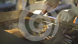 Hong Kong worker fries octopuses on stove in outdoor cafe