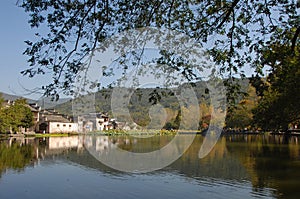 Hongcun Ancient Town in Anhui Province, China. Old buildings by Nanhu lake with trees and lilies