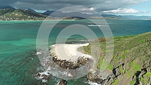 Honolulu, Hawaii, low angle view with drone camera moving backwards, beach on green island , color graded