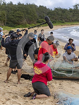 Honolulu, Hawaii, USA - 2022-08-20 - Shaka Filming Hukilau - A videographer films people preparing the net for the ocean