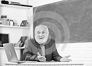 Honored professor. Teacher bearded man tell cheerful story. Teacher charismatic grandpa sit at table classroom