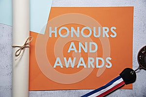 Honours and awards text on orange and baby blue background flat lay concept photo