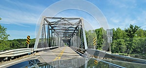 Hood bonnet of classic cadillac eldorado on the highway about to cross historic truss bridge wi river