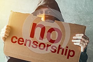 Hooded activist protestor holding No Censorship protest sign