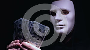 Hooded bandit in mask counting dollars, ransom for kidnapping victim, mafia