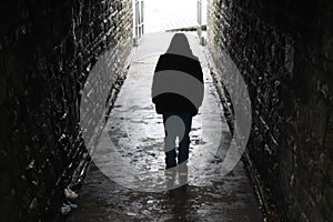 Hooded boy in an underground tunnel