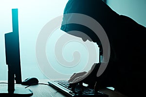 Hooded computer hacker hacking network