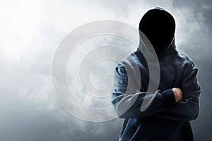 Hooded computer hacker on smoke background