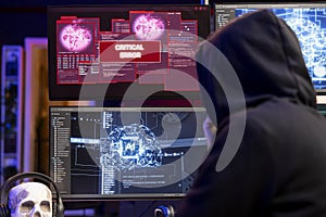 Hooded hacker getting critical error warning while doing computer sabotage