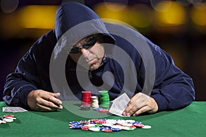 Hooded Male Poker Player with Cards