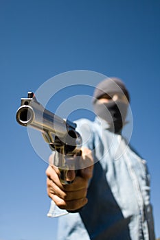 Hooded man with 44 magnum handgun threatening photo