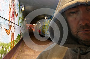 Hooded man in graffiti decorated subway