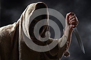 Hooded man with knife