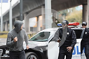 Hooded offender running from multicultural police