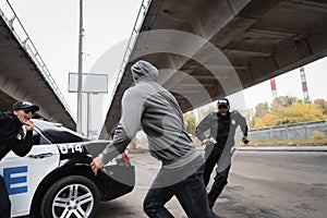 Hooded offender running from multicultural police