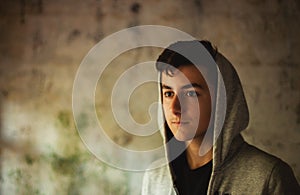 Hooded teenage boy in an abandoned house