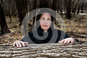 Hooded Woman in black robes deep in the Forest. Witches. Halloween and Gothic concept. Witchcraft and magic. Scary