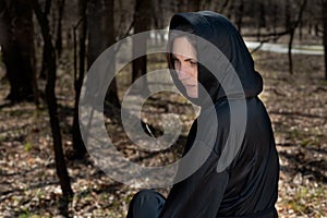 Hooded Woman in black robes deep in the Forest. Witches. Halloween and Gothic concept. Witchcraft and magic. Scary