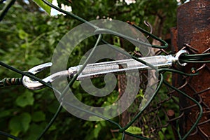 Hook lanyard holds a green trellis fence