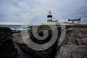 Hook Lighthouse landscape with cliffs and waves and peninsula Heritage center in Wexford, Ireland