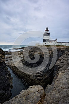 Hook Lighthouse landscape with cliffs and waves and peninsula Heritage center in Wexford, Ireland