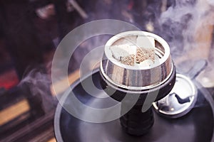 Hookah with burning coals is on the table.