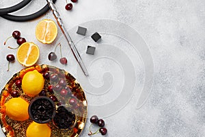 Hookah pipe and shaft with fruits on gray background