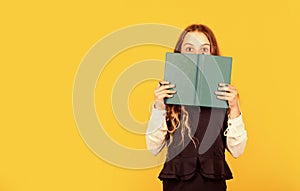 Hooked on book. Small child cover face with book. Little girl read book yellow background. Cute bookworm. Adorable