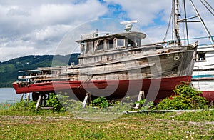 Historic but rotting fishing boats by ocean at Icy Strait Point