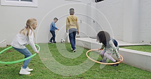Hoop, children and friends playing outdoor together, having fun and bonding at home backyard in summer. Group, kids and