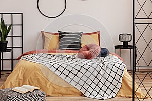 Hoops on a white wall in an elegant bedroom with orange bedding on the bed