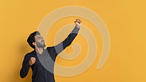 Hooray Concept. Overjoyed Young Indian Man Celebrating Success With Raised Fist