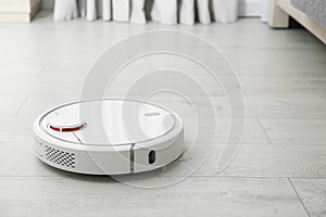 Hoovering floor with modern robotic vacuum cleaner. Space for text