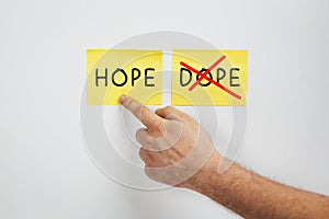 Hope or Dope, Cropped man hand choose Hope - A drug abuse or drug rehabilitation concept - Say no to Dope and yes to Hope photo