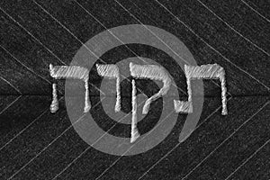 Hope in Hebrew language, stitched on fabric - monochrome